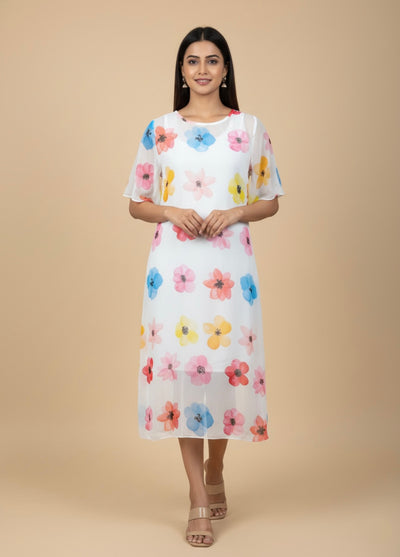 Woman wearing a white dress with colorful floral pattern on a beige background